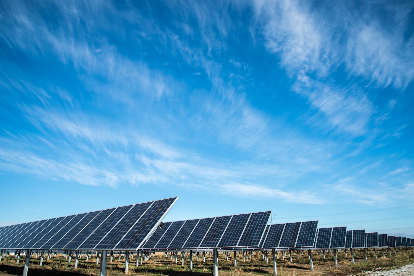 Field of solar photovoltaic panels under a blue sky — solar power feature.